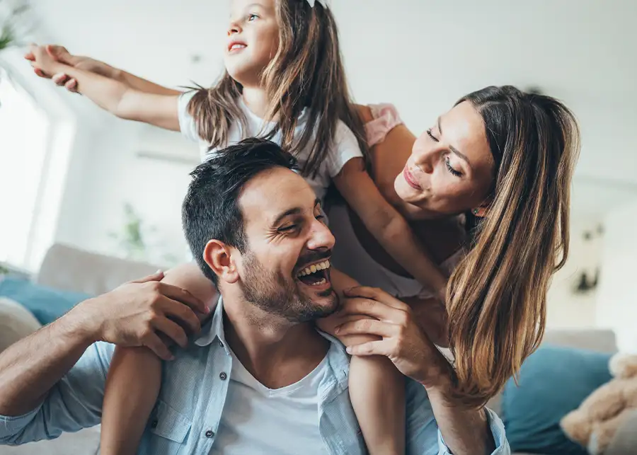 A happy family laughs and plays together in their comfortable home, enjoying the reliable climate control provided by Precision Climate Control in St. Charles, MO