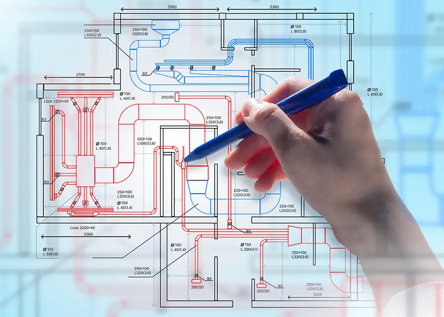 A hand sketches detailed HVAC system blueprints with red and blue duct routing, representing Precision Climate Control's custom duct design and installation planning in St. Charles, MO