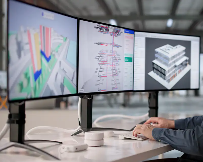 An HVAC engineer in St. Charles, MO works at a triple-monitor workstation displaying 3D building models and ductwork schematics, representing Precision Climate Control's advanced system design capabilities