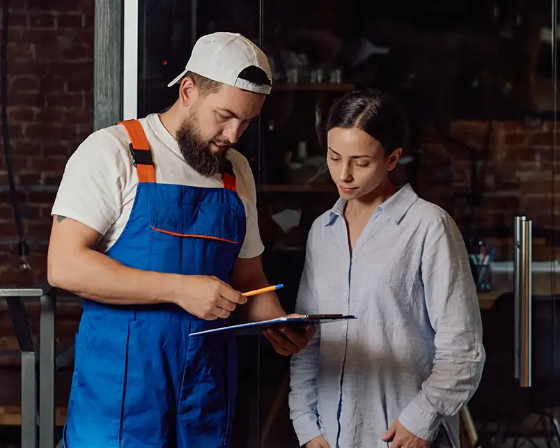 A Precision Climate Control technician reviews a service clipboard with a homeowner in St. Charles, MO, explaining system findings and next steps