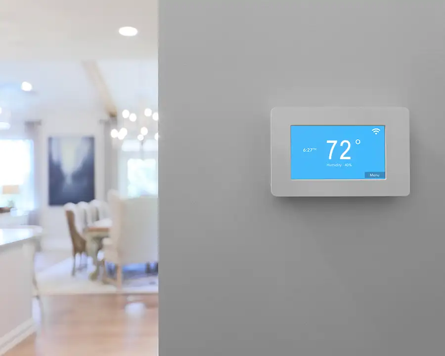A Wi-Fi enabled smart thermostat mounted on a gray wall displays 72 degrees and 40% humidity with a bright blue touchscreen, representing Precision Climate Control's smart home climate upgrades in St. Charles, MO